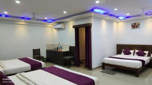 Pokój hotelowy z 2 łóżkami z fioletowymi światłami na suficie w obiekcie Coorg ASHOK PALACE w mieście Madikeri