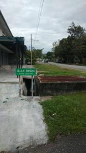 a green street sign in front of a building at IPOH Homestay in Ipoh