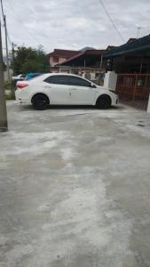 een witte auto geparkeerd op een parkeerplaats bij IPOH Homestay in Ipoh