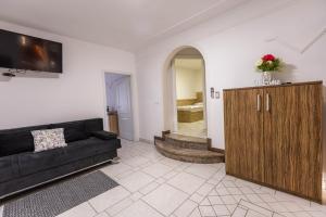 a living room with a black couch and a wooden cabinet at Apartmaji Natura KOLPA in Adlešiči