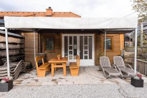 Adlešiči的住宿－Apartmaji Natura KOLPA，一个带桌椅的庭院和一个帐篷