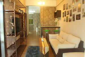 a living room with a white couch and a brick wall at 1 MINUTES TO TOWER SENTRAL INTAN HOMESTAY 6 ROOMS in Teluk Intan
