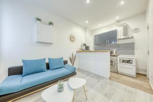 un soggiorno con divano blu e una cucina di Appartement COSY, central LA DEFENSE, très proche PARIS a Courbevoie