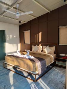 Miracle Hotel and Resorts في كوجيكود: غرفة نوم بسرير كبير عليها منشفتين