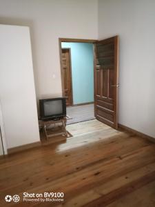 una habitación vacía con TV y puerta en Casa del Campo en Tela