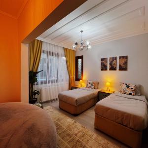 two beds in a room with orange walls at Triplex house with Bridge view in Istanbul