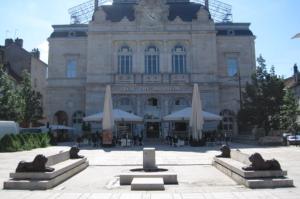 a building with tables and umbrellas in front of it at Chambre paisible avec vue sur la montagne in Conliège