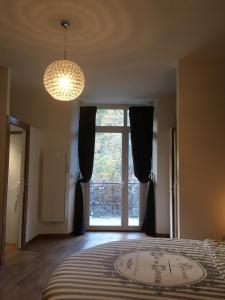 sypialnia z dużym łóżkiem i dużym oknem w obiekcie Chambre paisible avec vue sur la montagne w mieście Conliège