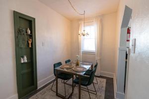 a dining room table with chairs and a green door at Historic Revival King Bed Midtown Memphis 68 Yes Pets Fast Wifi Free Parking in Memphis