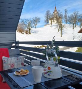 a table with a tea kettle and a plate of food at Apartmaji Pr Smolet in Selca