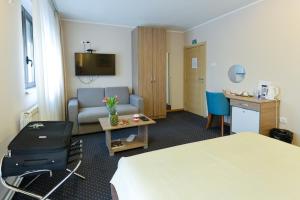 a hotel room with a bed and a couch and a table at Smeštaj Tank, Pančevo in Salaši