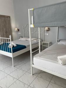 a bedroom with two bunk beds with blue sheets at WHITE STUDIOS in Himare