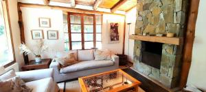 sala de estar con sofá y chimenea en Casa en Zapallar con hermosa vista y jardín., en Zapallar