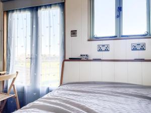 a bedroom with a bed and two windows at The Hut in Langstone