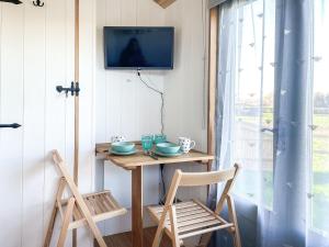 a small table with two chairs and a tv on a wall at The Hut in Langstone