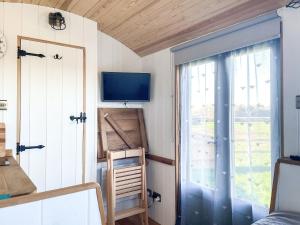 a tiny house with a window and a tv at The Hut in Langstone