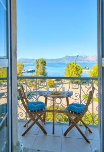 balcón con mesa, sillas y vistas al agua en Anesis Apartment Corfu Town en Corfú