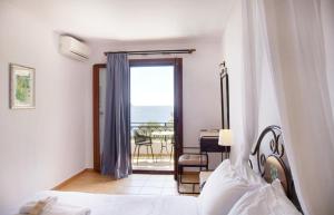 a bedroom with a bed and a view of the ocean at Kekrifalia Hotel in Skala