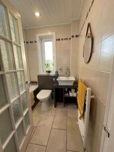 a bathroom with a toilet and a sink and a mirror at Beachfront Treasure in Musselburgh