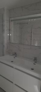 une salle de bain blanche avec deux lavabos et un miroir dans l'établissement GITE DE LA COMBE BASSE, à Le Masnau-Massuguiès 16 autres photos