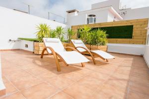 een groep stoelen en tafels op een balkon bij atico en el centro del castillo CASA KIKO in Peñíscola