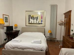 Cette chambre comprend un lit avec des draps blancs et un bureau. dans l'établissement Once Upon a Time, à Bologne
