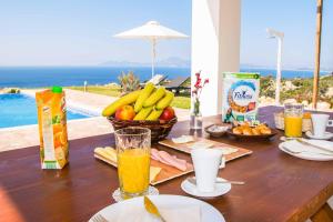 una mesa de madera con fruta y zumo encima en The Three Graces - Apollon, en Antimácheia