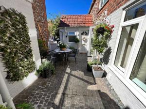 a small patio with a table and a house at Anchor Cottage - beautiful two bedroom cottage in the heart of Holt in Holt