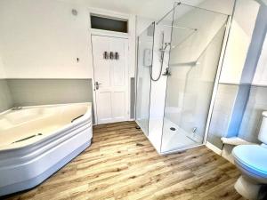 霍尔特Anchor Cottage - beautiful two bedroom cottage in the heart of Holt的带浴缸、淋浴和卫生间的浴室 更多27张照片