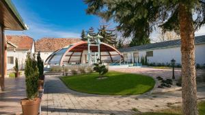 a building with a dome and a courtyard with a garden at Aquasol Resort in Mosonmagyaróvár