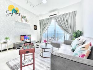 a living room with a couch and a table at SilverScape Residence I Luxury 2-4 BR I 6-11 pax I Bathtub I Seaview I Infinity Pool I Jonker St I City Centre by Jay Stay Management in Melaka