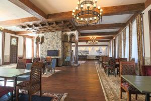 a dining room with tables and chairs and a chandelier at Knyazli Family Suites & Rooms in Kiçik Qaramurad