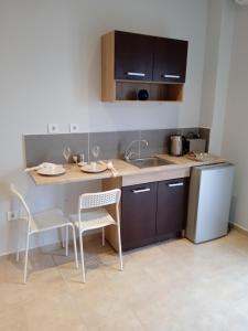 cocina con mesa, sillas y fregadero en Aelia Boutique Apartments en Argostoli