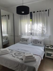 ein Schlafzimmer mit einem großen weißen Bett mit i love kissen in der Unterkunft הפינה בנחל in HaGoshrim