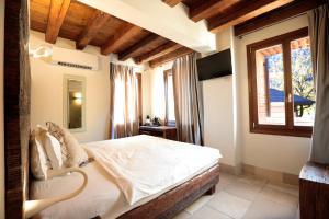 a bedroom with a bed and a large window at Hotel Antica Abbazia in Borso del Grappa
