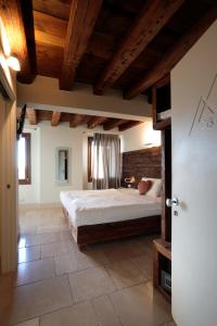 a bedroom with a large bed and wooden ceilings at Hotel Antica Abbazia in Borso del Grappa