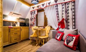 a living room with a couch and a table in a kitchen at Apartamenty u Stopków in Biały Dunajec