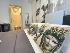 a bed with two pillows with faces on it at I Cinque Mori DEVA in Siracusa
