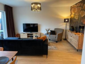 uma sala de estar com um sofá, uma televisão e uma cadeira em Q Geraardsbergen em Geraardsbergen