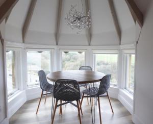 - une salle à manger avec une table, des chaises et des fenêtres dans l'établissement Beach View Apartment, à Saltburn-by-the-Sea
