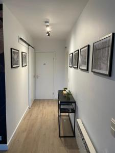 a hallway with a table and pictures on the walls at Q Geraardsbergen in Geraardsbergen
