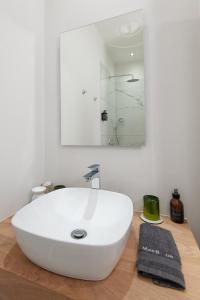 a bathroom with a white sink and a mirror at Glow Boutique Suites in Hermanus