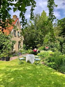 een tafel en stoelen in de tuin van een huis bij Theetuin en B & B 'De Theetuin' in Wijckel