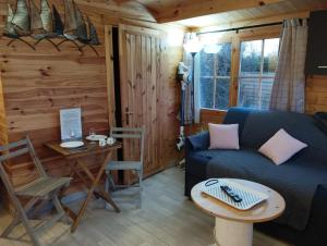 uma sala de estar com um sofá e uma mesa em Gîtes entre mer et campagne, 3km de Berck les chalets du Fliers em Berck