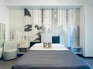 a bedroom with a large bed and two chairs at I Cinque Mori DEVA in Siracusa