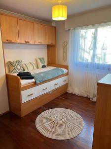 1 dormitorio con cama, ventana y alfombra en Piso Confort y Detalles Ourense, en Ourense