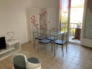 a dining room with a glass table and chairs at L olivier in Prades