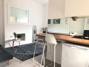 a kitchen with a counter and two stools in a room at Bright one bedroom apartment in Chiswick in London