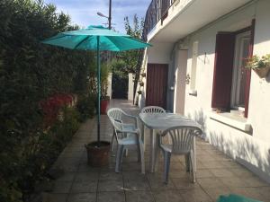 a table and chairs with an umbrella on a patio at L olivier in Prades