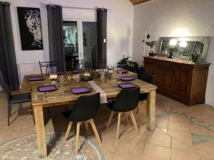La Villa Coisy في سان غالمير: طاولة خشبية في غرفة معيشة مع كراسي حولها